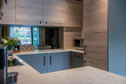 a kitchen with wooden cabinets and a counter top at The Quadrant - The Ruskin Suite in York