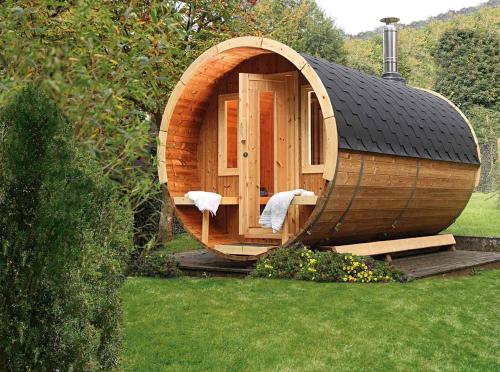 a small wooden sauna in a yard with a grass at Ferienhaus Pichl in Bruck an der Großglocknerstraße