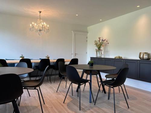 a dining room with tables and chairs and a chandelier at Tuss in Kortrijk