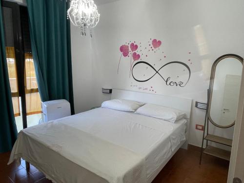 a bedroom with a bed and a sign that says love at La terrazza sul MARE Manfredonia in Manfredonia