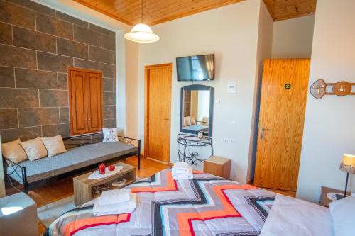 a living room with a bed and a couch at Gkoura hotel in Syrrako