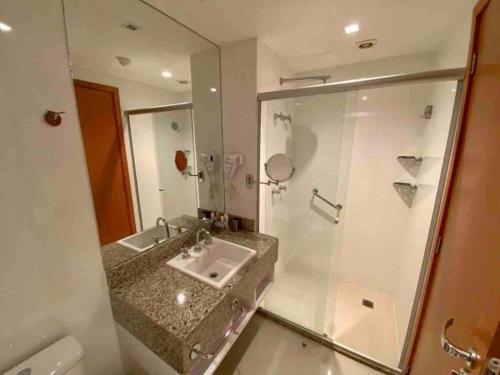 y baño con lavabo y ducha. en Brisas do Lago - Apartamento 3, en Brasilia