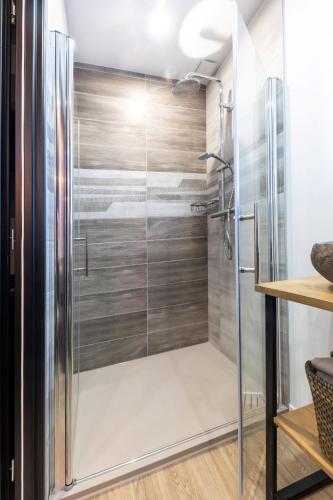 une douche avec une porte vitrée dans une salle de bain dans l'établissement Le Cinq : Appartement Chic&Cosy, jardin privatif, à Vesoul