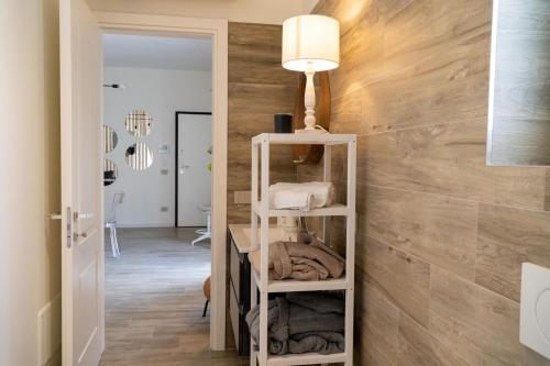 Habitación con pared de madera y estante con toallas. en Blanco - MAGNIFICENT B&B Altamura en Altamura
