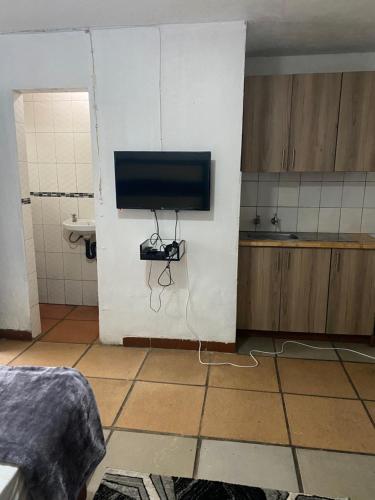 Soweto Towers Guest Accommodation في سويتو: غرفة مع تلفزيون على جدار في الحمام