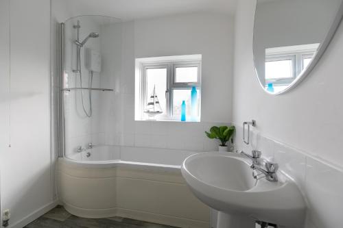 a white bathroom with a sink and a bath tub at Ludlow Drive 3 bed Contractor family Town house in melton Mowbray in Melton Mowbray