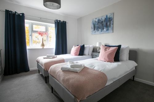 duas camas num quarto com cortinas azuis em Ludlow Drive 3 bed Contractor family Town house in melton Mowbray em Melton Mowbray