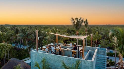 a view of a resort with a pool and palm trees at Maya Tulum By G Hotels in Tulum