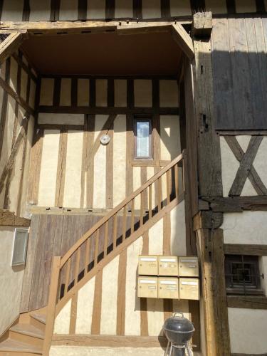 una escalera de madera que conduce a un edificio en Au joli Barséquanais, en Bar-sur-Seine
