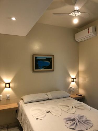 a bedroom with a bed and two night stands at Pousada Escotilha in Arraial do Cabo