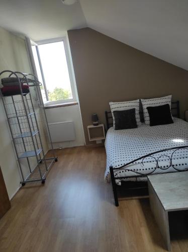 a bedroom with a bed and a large window at La Cabanette in Saint-Agrève
