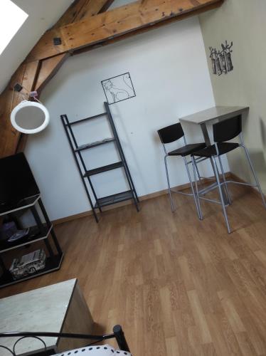 an attic room with a table and chairs and a desk at La Cabanette in Saint-Agrève