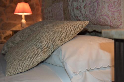 a pillow on top of a bed with a lamp at Airiños de Mondariz in Mondariz