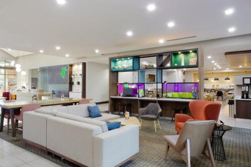 a lobby with a couch and a table and chairs at Holiday Inn & Suites Phoenix Airport by IHG in Phoenix