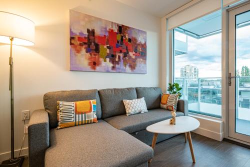 ein Wohnzimmer mit einem Sofa und einem Tisch in der Unterkunft Charming Oasis Close to Airport & Downtown Views in Richmond