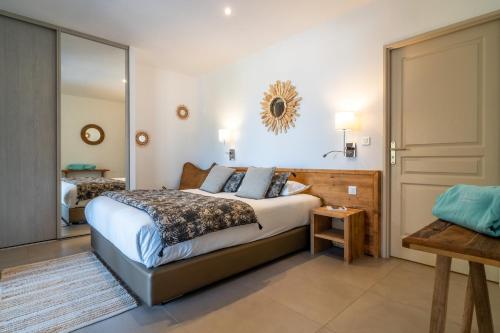 a bedroom with a large bed and a mirror at Résidence U Frusteru in Propriano