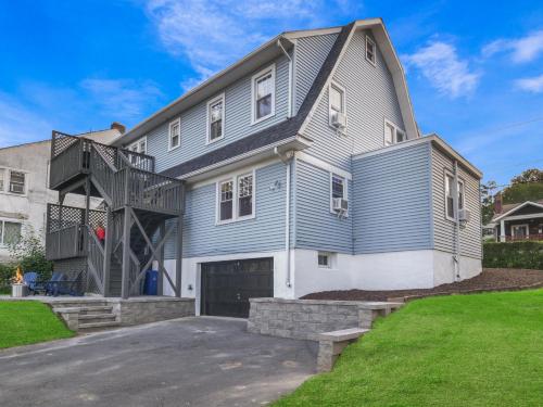 a large blue house with a garage at Deck View of Hudson River & Mt Beacon / Boho Suite in Newburgh