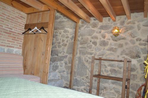 a bedroom with a stone wall and a lamp at Airiños de Mondariz in Mondariz