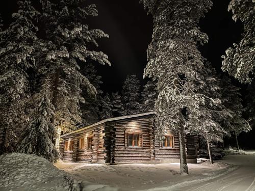 una cabaña de madera en la nieve por la noche en Cottis - Kultakettu en Levi