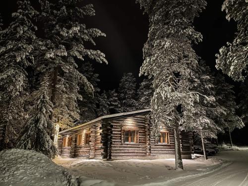 a log cabin in the snow at night at Cottis - Kultakettu in Levi