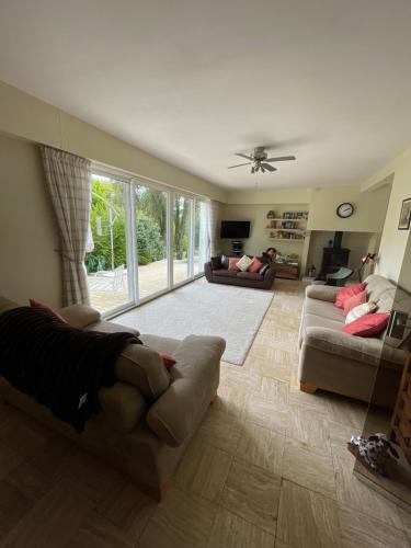 - un salon avec deux canapés et un ventilateur de plafond dans l'établissement Kerprimel, à Saint-Thois