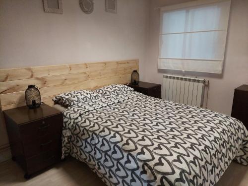 Schlafzimmer mit einem Bett mit einer schwarzen und weißen Bettdecke in der Unterkunft navas suite in Navas del Rey
