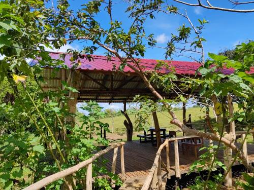 a wooden deck with a red roof at Onca Tours & Treehouses in San Rafael