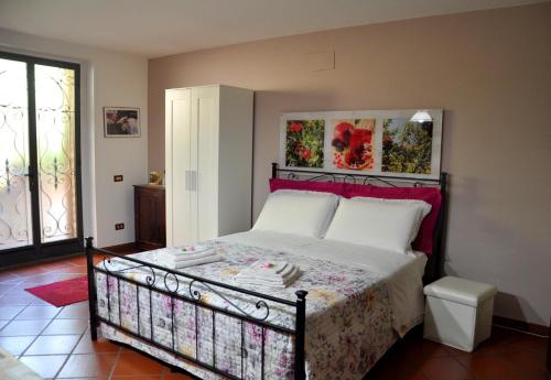 a bedroom with a bed with a red headboard at La Collina del Melograno in Sinalunga