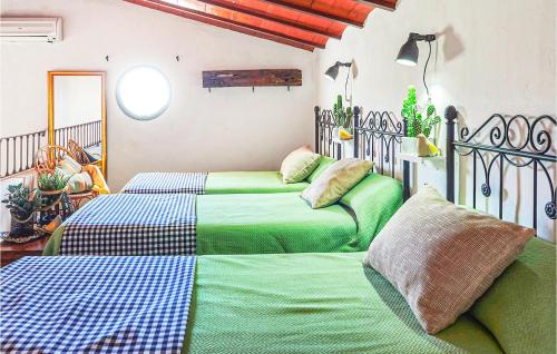 - 2 lits dans une chambre de couleur verte et bleue dans l'établissement Cozy Home In Estepa With Kitchen, à Estepa