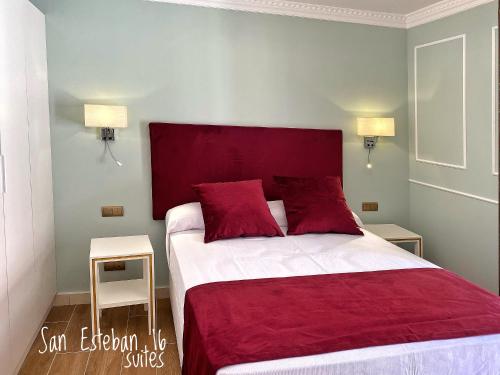 ein Schlafzimmer mit einem großen Bett mit roter Bettwäsche und Kissen in der Unterkunft SUITES SAN ESTEBAN 16 Principe in Sevilla