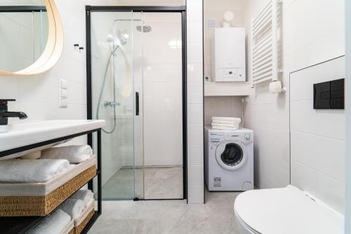 y baño con ducha y lavadora. en Z SAUNĄ, BLISKO WYCIĄGU - Osada Wilczy Potok, en Szczyrk