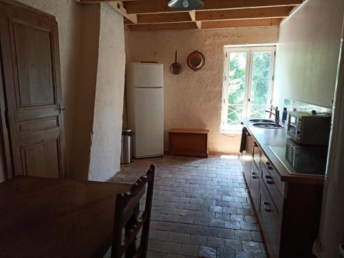 eine Küche mit einem weißen Kühlschrank und einem Fenster in der Unterkunft La Vie Là, Chasselay in Chasselay