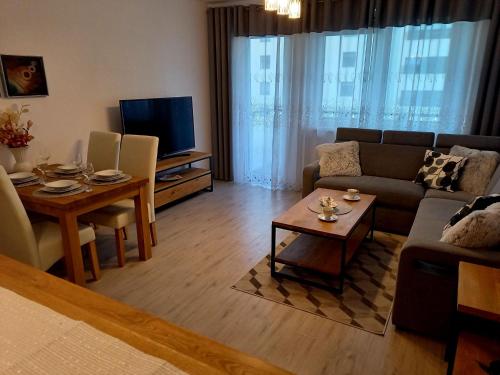 una sala de estar con un sofá y una mesa en Apartament Green Park, en Starogard Gdański