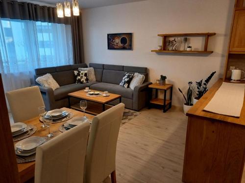 una sala de estar con un sofá y una mesa en Apartament Green Park, en Starogard Gdański