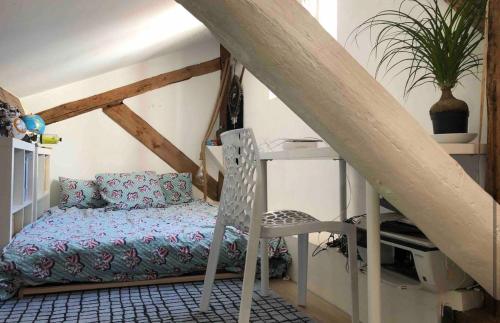 Cette chambre mansardée comprend un canapé et une chaise. dans l'établissement Coeur de Lyon avec Terrasse et Jacuzzi, à Lyon