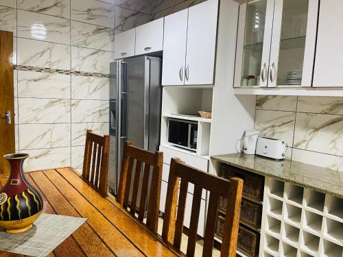 a kitchen with white cabinets and a table and chairs at Januario Maputo in Maputo