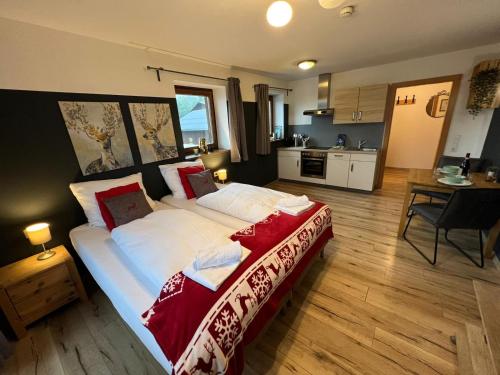 a bedroom with a large bed and a kitchen at Apartments Chalet Sonnentanz in Piesendorf