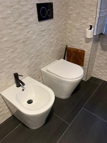 a bathroom with a white sink and a toilet at Minardi Apartments in Vercelli
