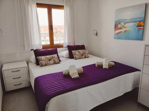 a bedroom with a bed with purple sheets and a window at Apartamentos Los Balandros by SunHousesCanarias in Maspalomas