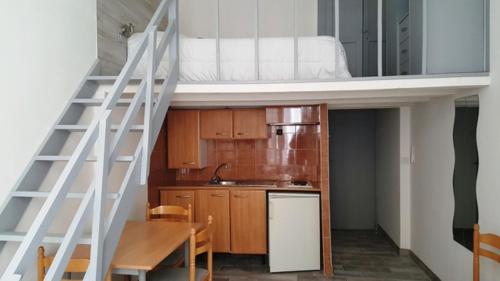 Habitación con cama elevada y cocina. en STUDIOS PARISIENS, en Cannes