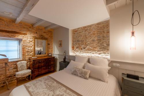 - une chambre avec un lit et un mur en pierre dans l'établissement Château de Champ-Renard, à Blacé