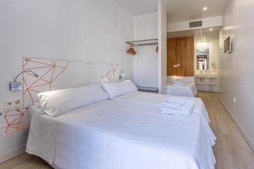 a bedroom with a large white bed with white sheets at AMC Granada Hostal in Granada