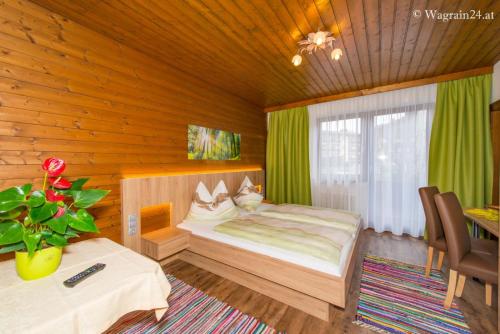 ein Schlafzimmer mit einem Bett in einem Holzzimmer in der Unterkunft Pension Montana in Wagrain