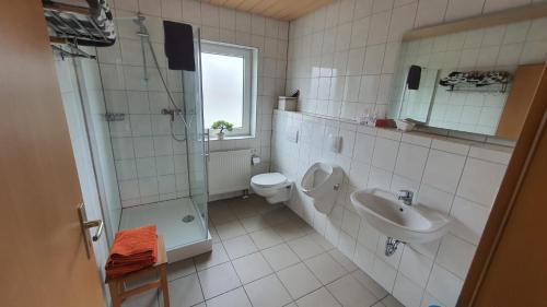 y baño con ducha, aseo y lavamanos. en Ferienwohnung am Ring, en Baar