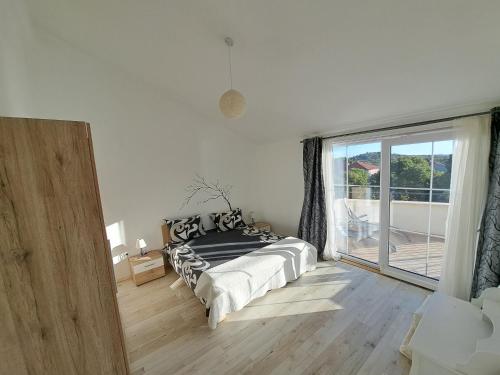 Un dormitorio con una cama y una ventana grande. en Apartment Oaza Mira, en Tribunj
