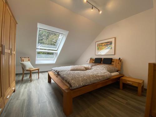 a bedroom with a bed and a chair and a window at Ferienhaus Xantenamera in Xanten-Wardt am See in Xanten