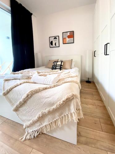 ein Schlafzimmer mit einem Bett mit einer Decke darauf in der Unterkunft Warsaw Concierge Fabryka na Pradze in Warschau