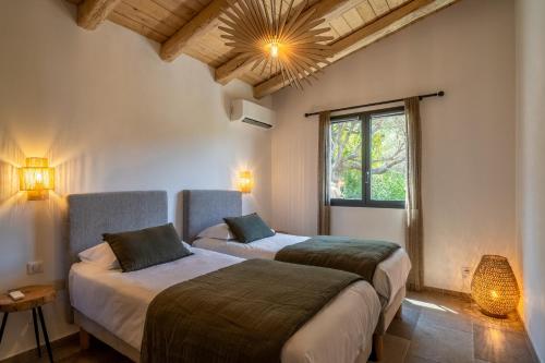 a bedroom with two beds and a window at Résidence U Frusteru in Propriano