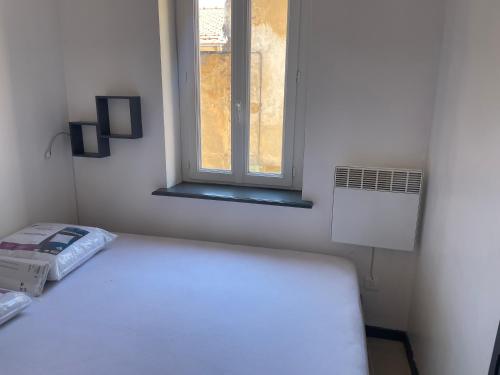 Habitación pequeña con cama y ventana en Trophée d'Auguste en La Turbie