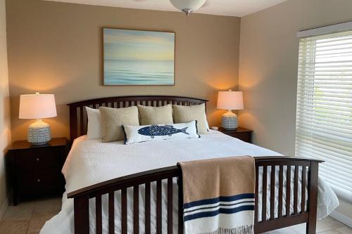 a bedroom with a large bed with two lamps at Dockside Destiny in St Pete Beach